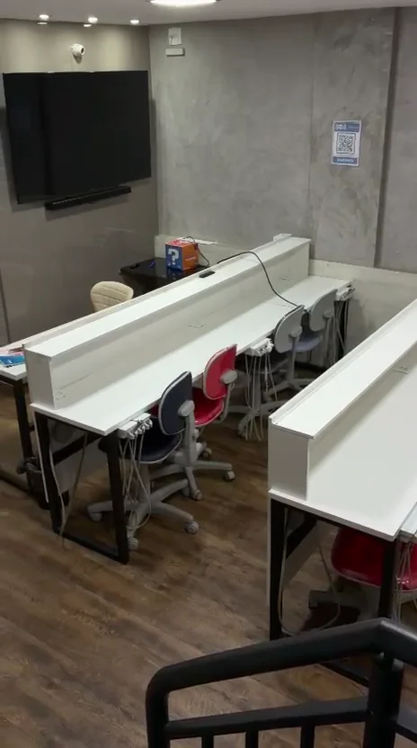 Sala de treinamento da JC Dental com bancadas e estações de trabalho